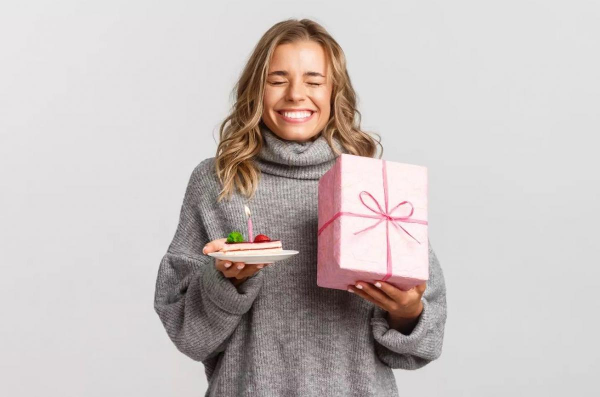 Une femme avec un cadeau et une pâtisserie